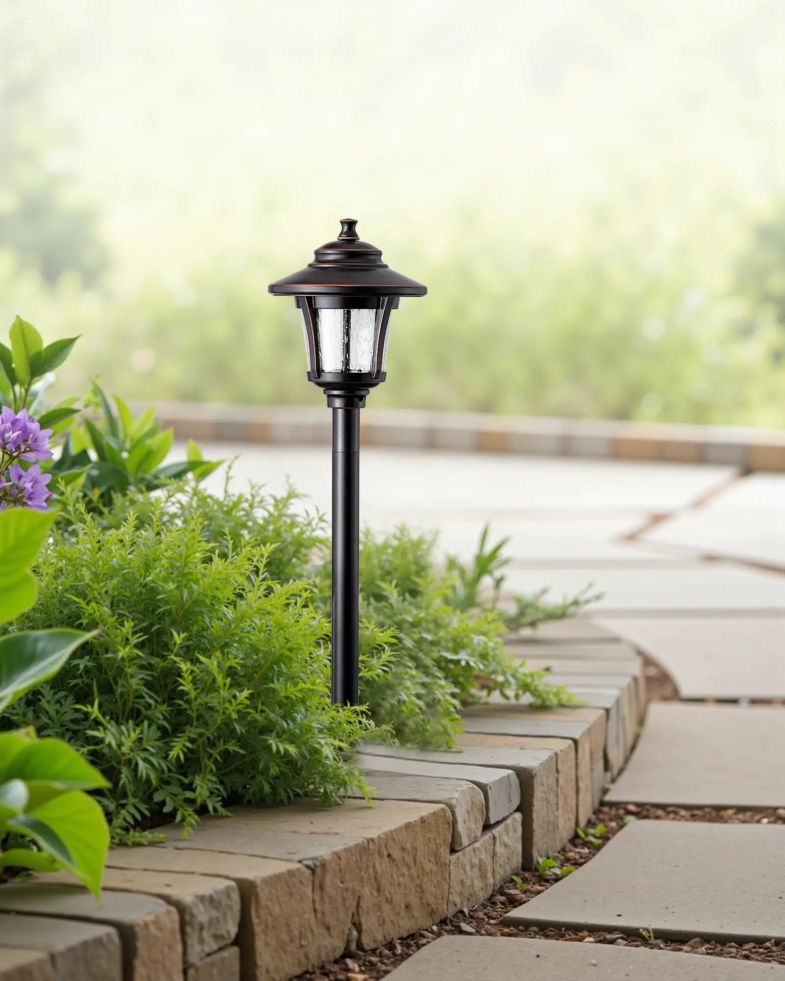 Garden lamp post with greenery on a stone pathway