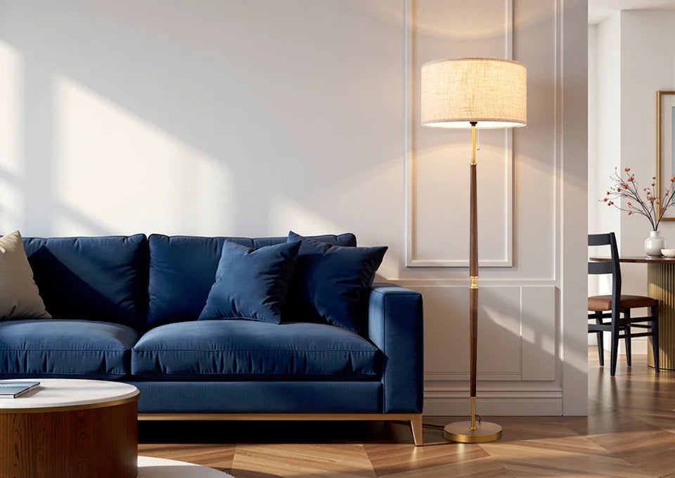 Modern living room with a blue sofa, lamp, and wooden floor.