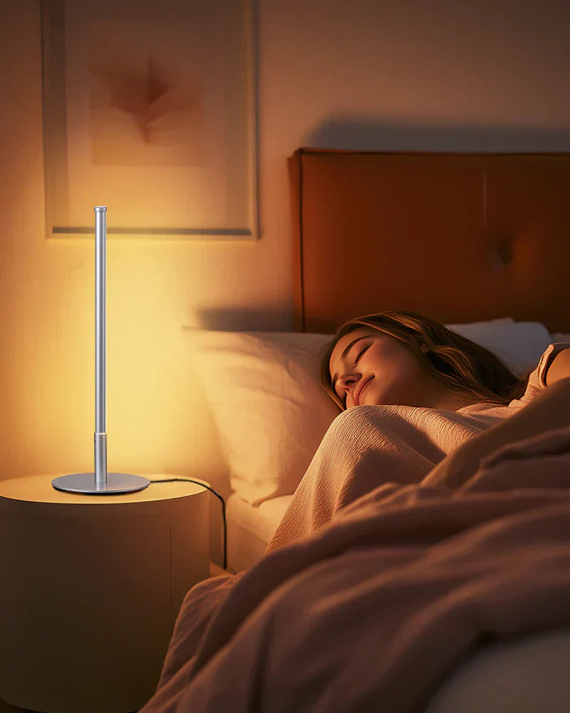 A-person-resting-quietly-in-bed-with-a-table-lamp-beside-them-emitting-a-soft-red-or-warm-amber-orange-glow