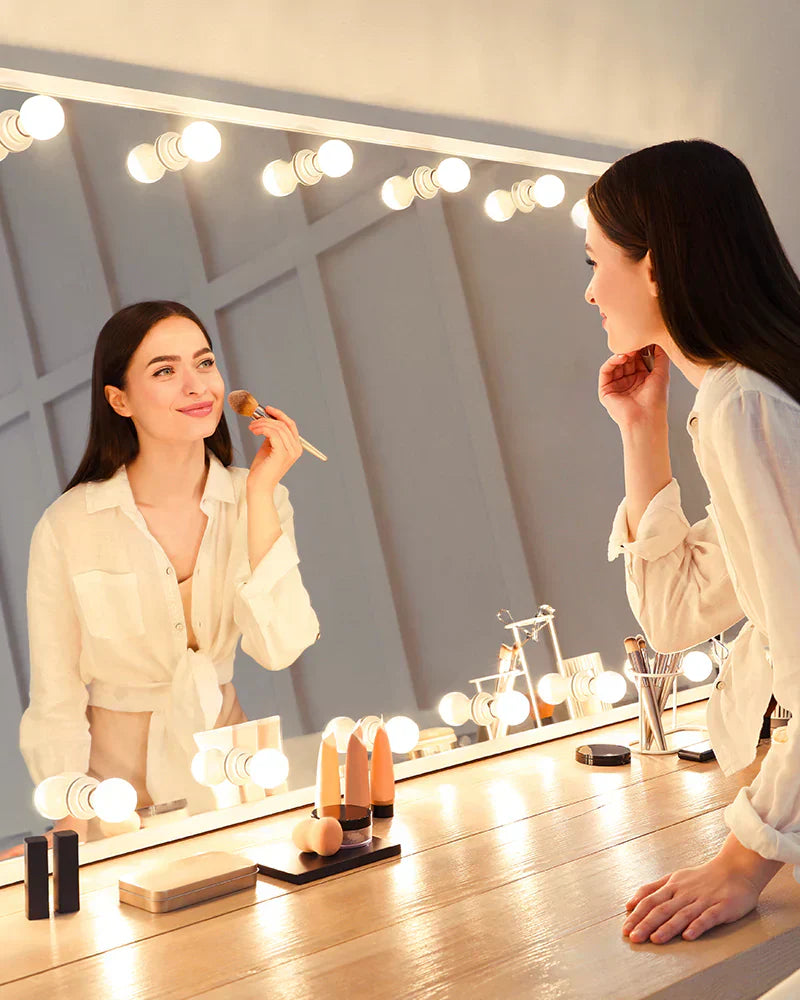 A-woman-applying-makeup-in-front-of-a-vanity-mirror-with-glare-free-lighting