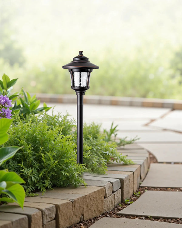 Garden lamp post with greenery on a stone pathway