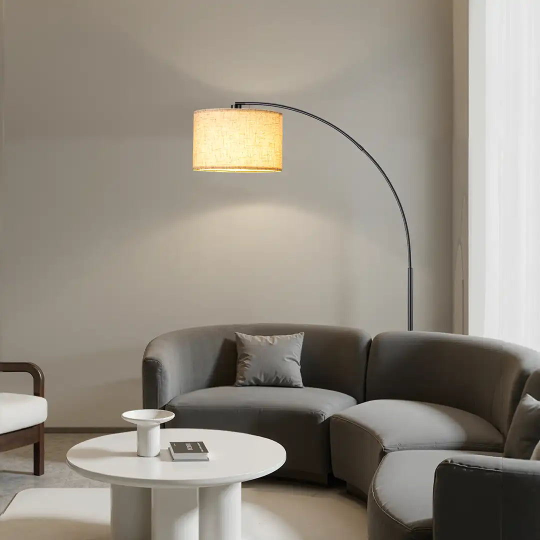 Modern living room with a gray sofa, white coffee table, and floor lamp.