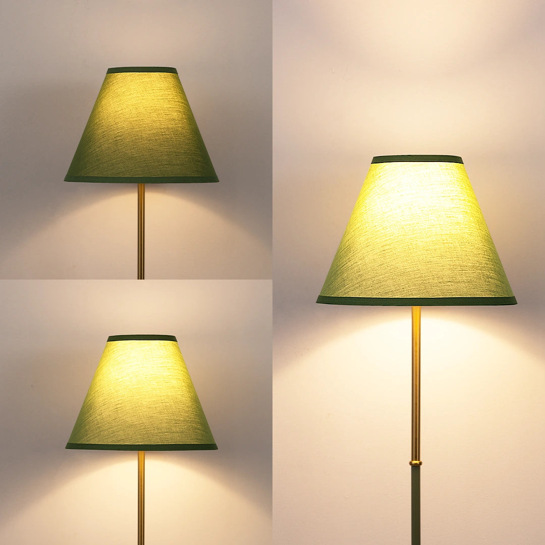 Green lampshade on a gold stand against a neutral background