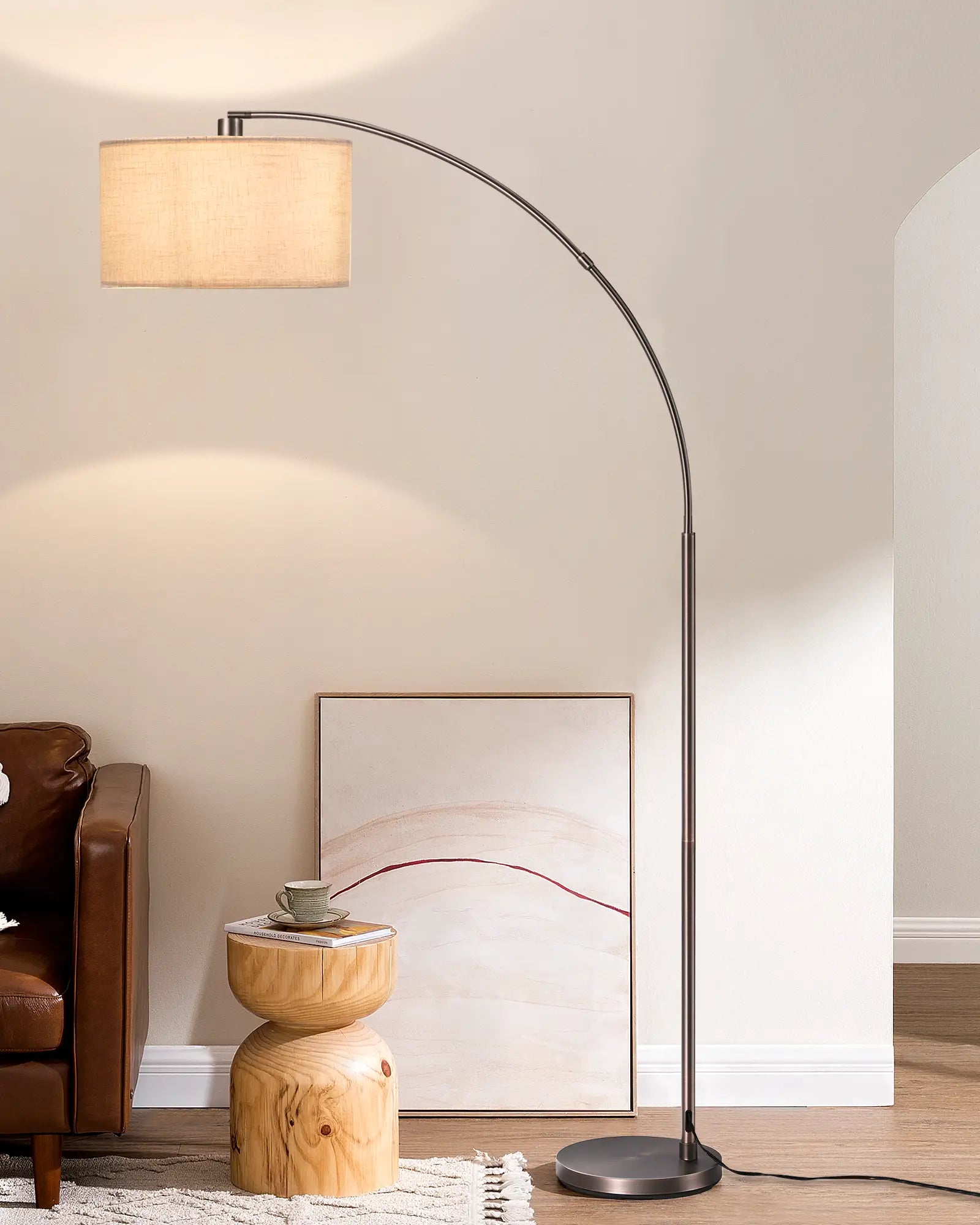 Arc floor lamp in a living room setting with a brown armchair and wooden side table.