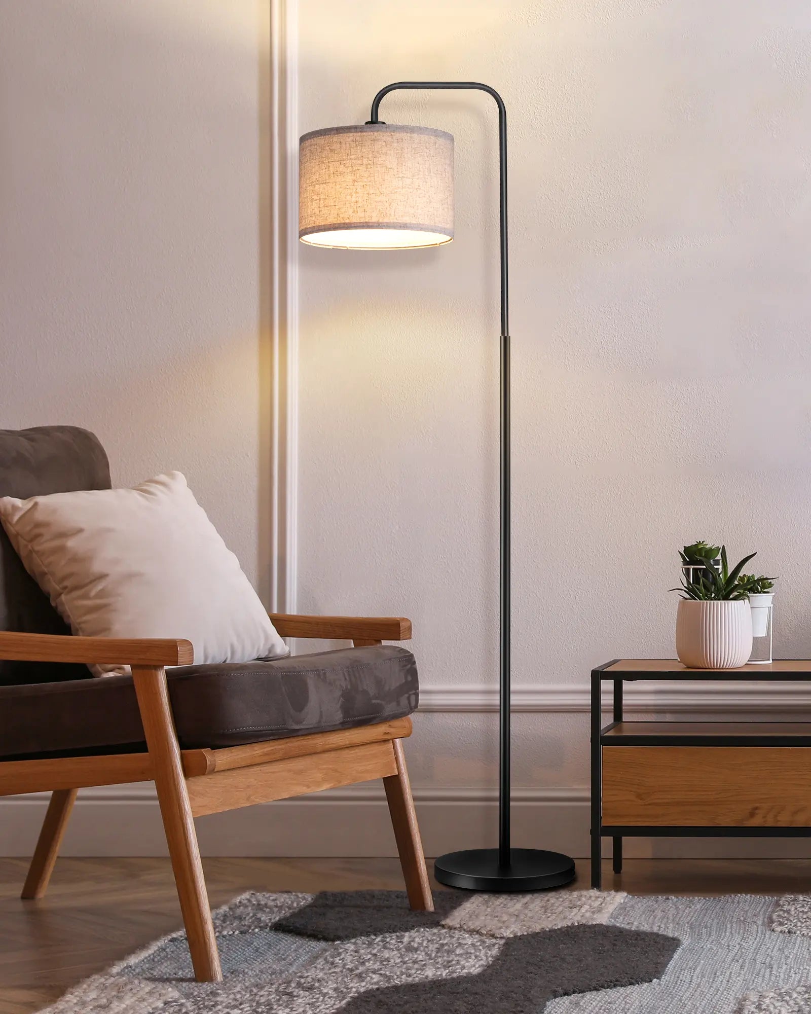 Modern floor lamp in a living room setting with a chair and small table.