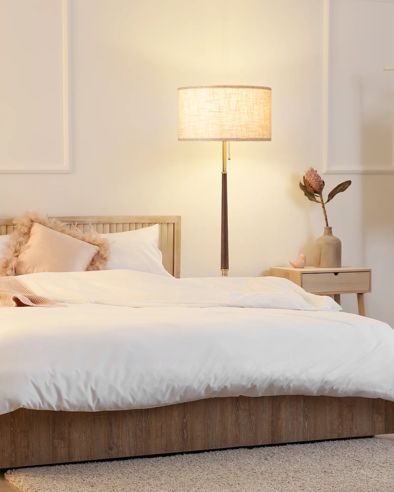 Bedroom with a bed, lamp, and side table.