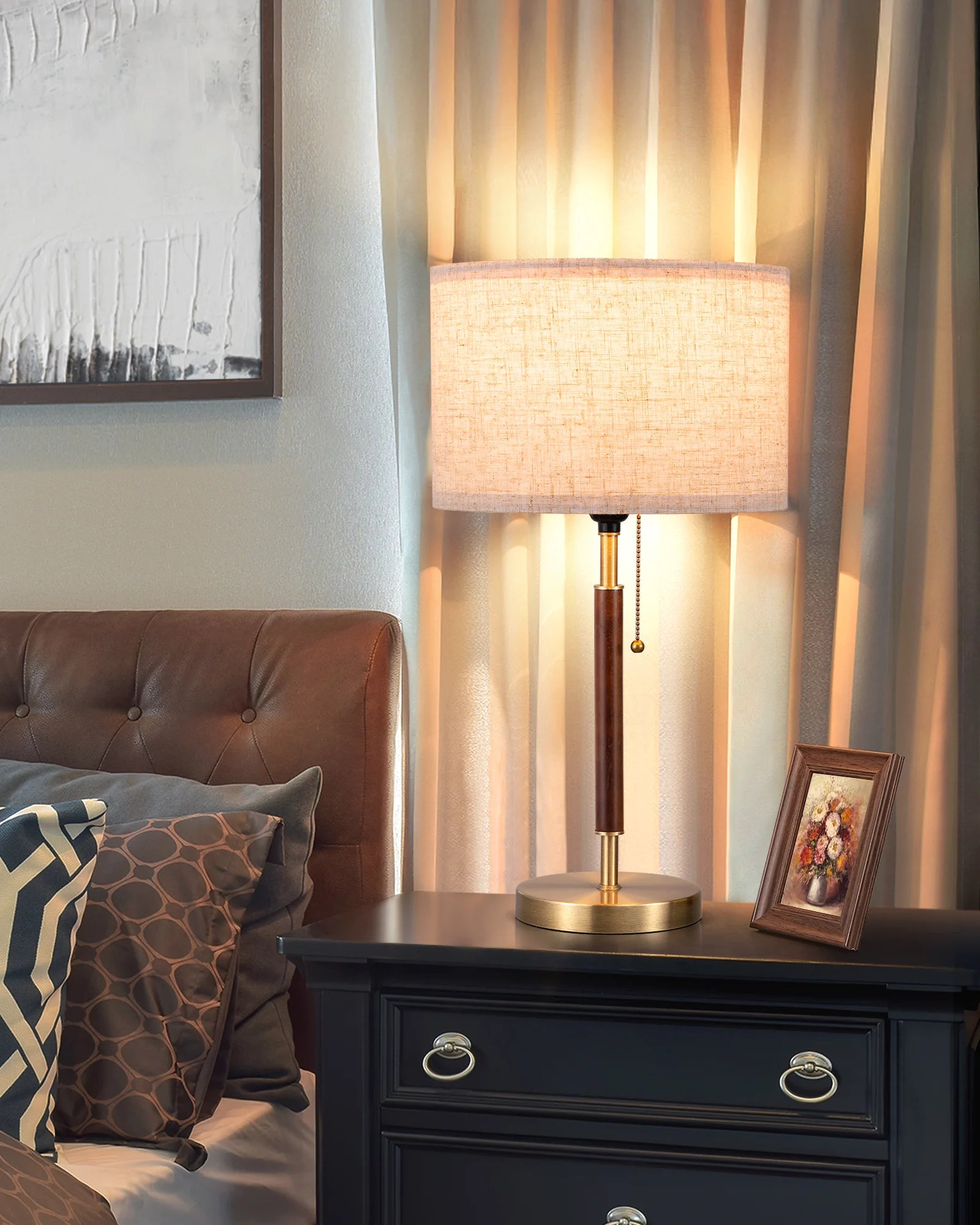 Table lamp on a nightstand with a brown leather chair and decorative pillows in the background.