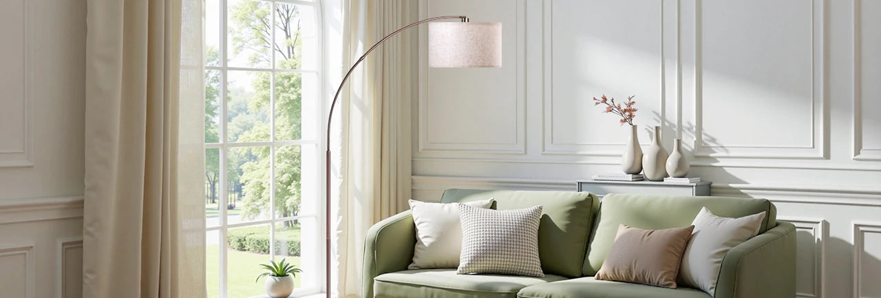 Green sofa with decorative pillows in a bright living room with large windows.