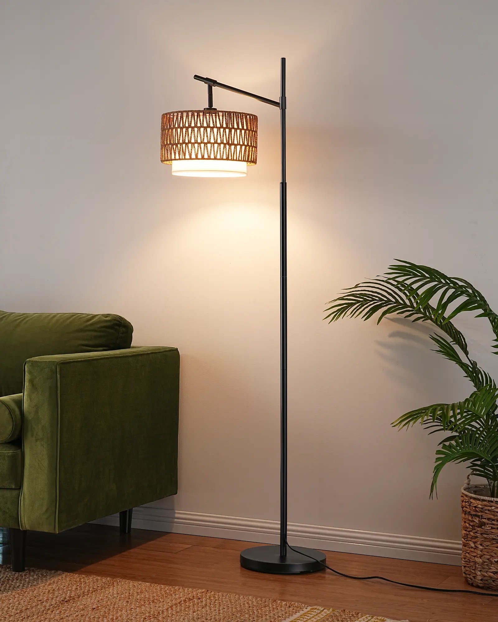 Floor lamp with wicker shade in a room with a green armchair and plant.
