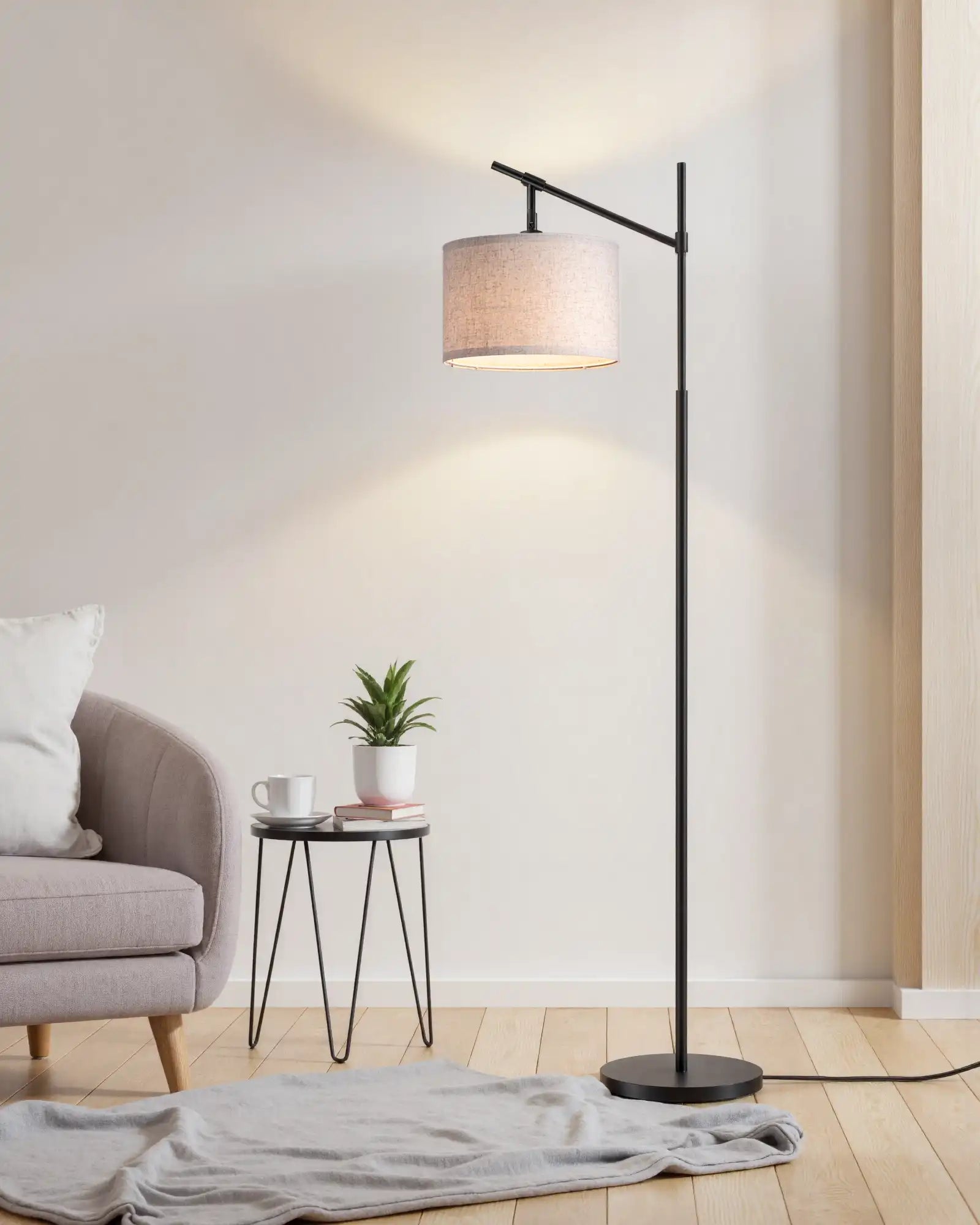 Modern floor lamp in a living room setting with a side table and plant.
