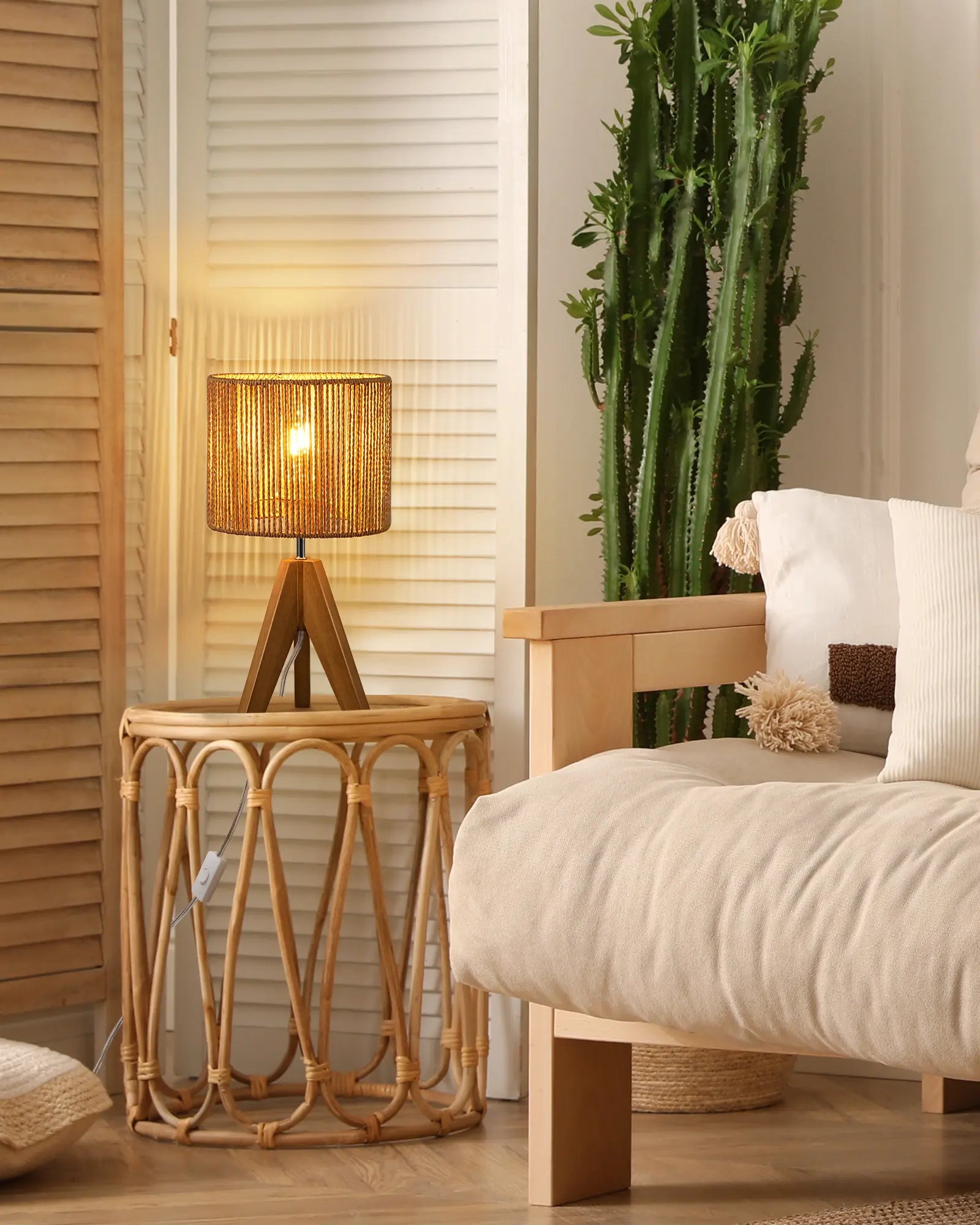 Rattan side table with lamp next to a beige armchair in a cozy room.