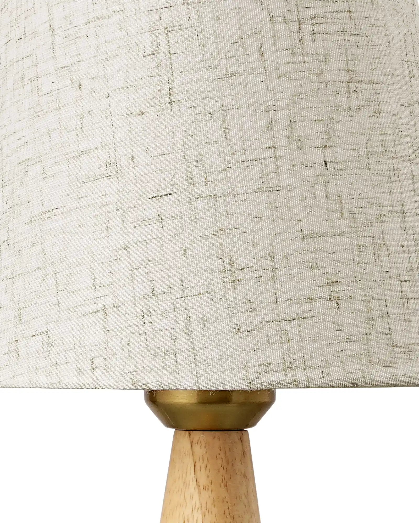 Close-up of a Linen Table Lamp  with a textured beige shade and wooden base.