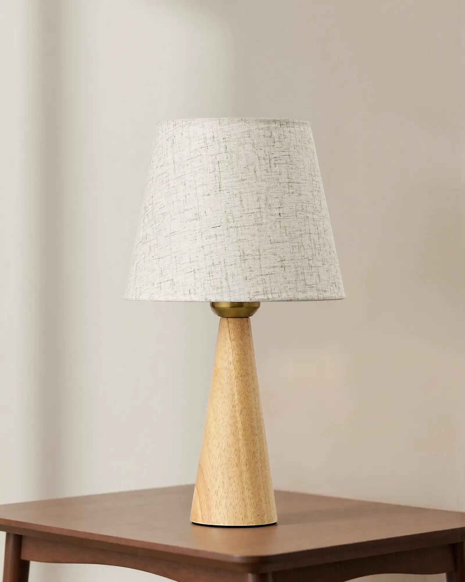 Scandinavian Minimal Linen Table Lamp with a wooden base and textured white shade on a wooden table.