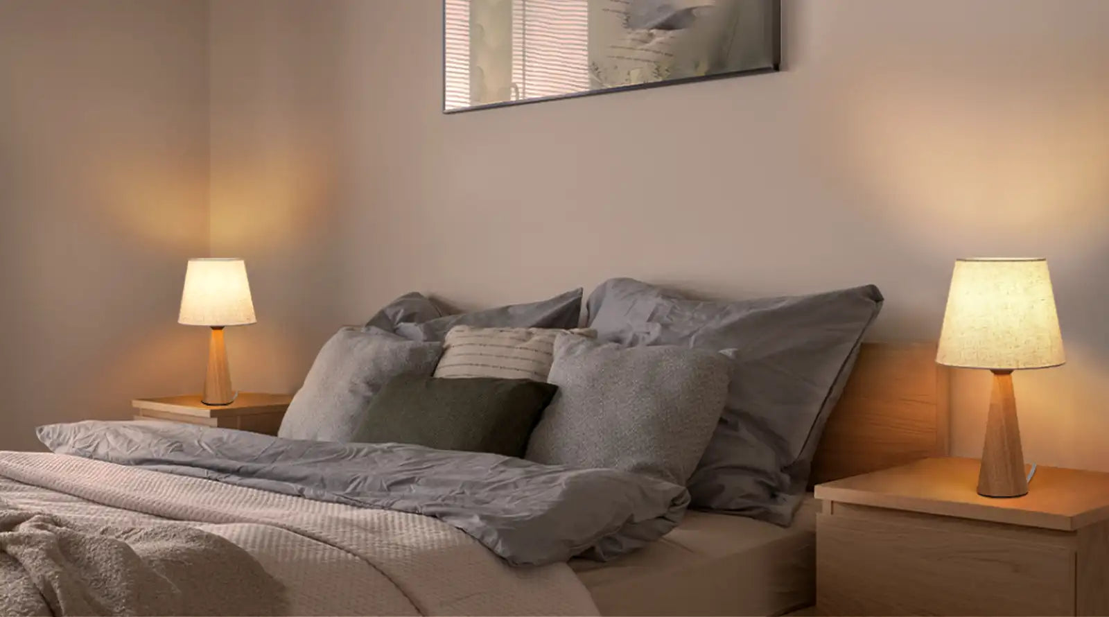 Bedroom with a bed featuring gray bedding and pillows, two Linen Table Lamps on nightstands, and a framed picture on the wall.