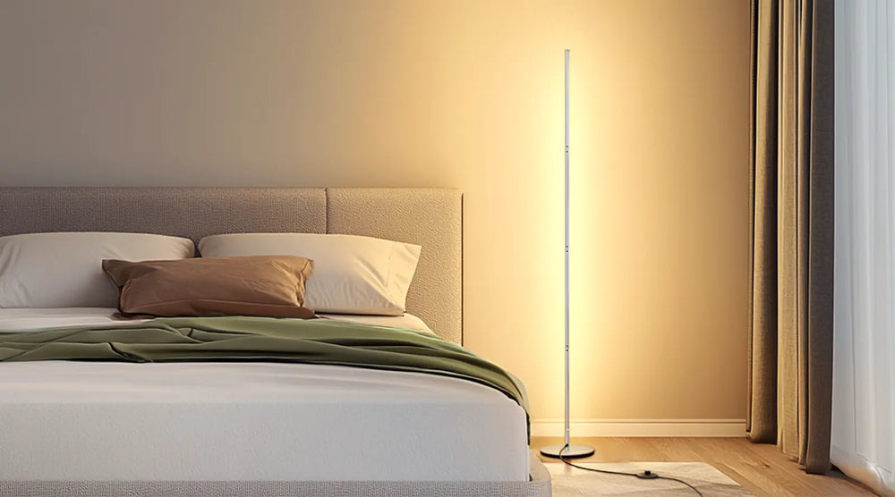 Bedroom with a bed and a standing lamp casting a warm glow.