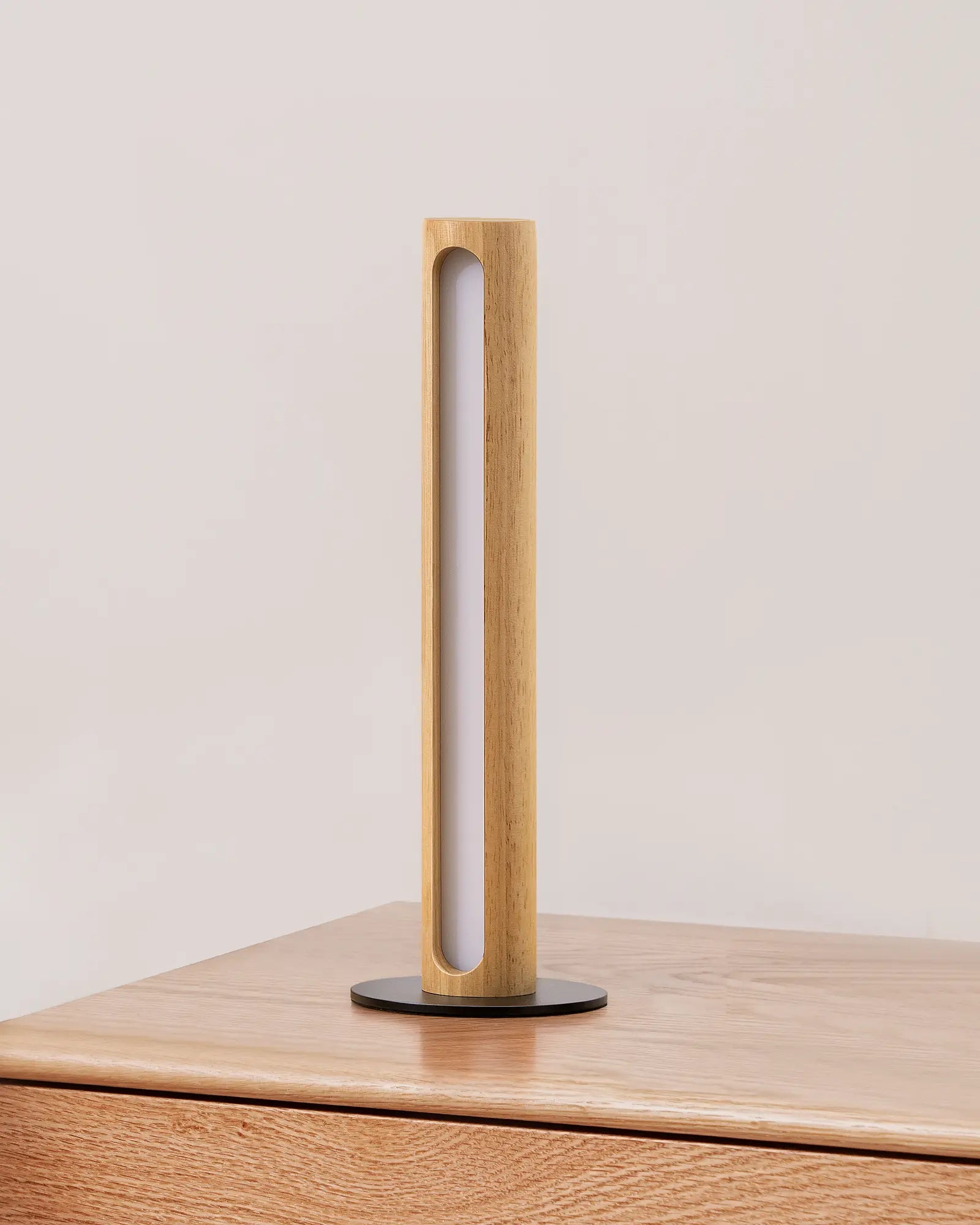 Minimalist Wood Cylinder Table Lamp on a wooden surface with a plain background