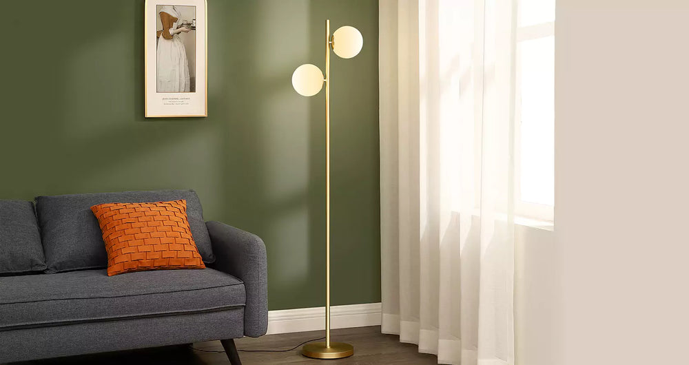Living room with gray sofa, orange pillow, and gold Modern Sphere Standing Light against a green wall.