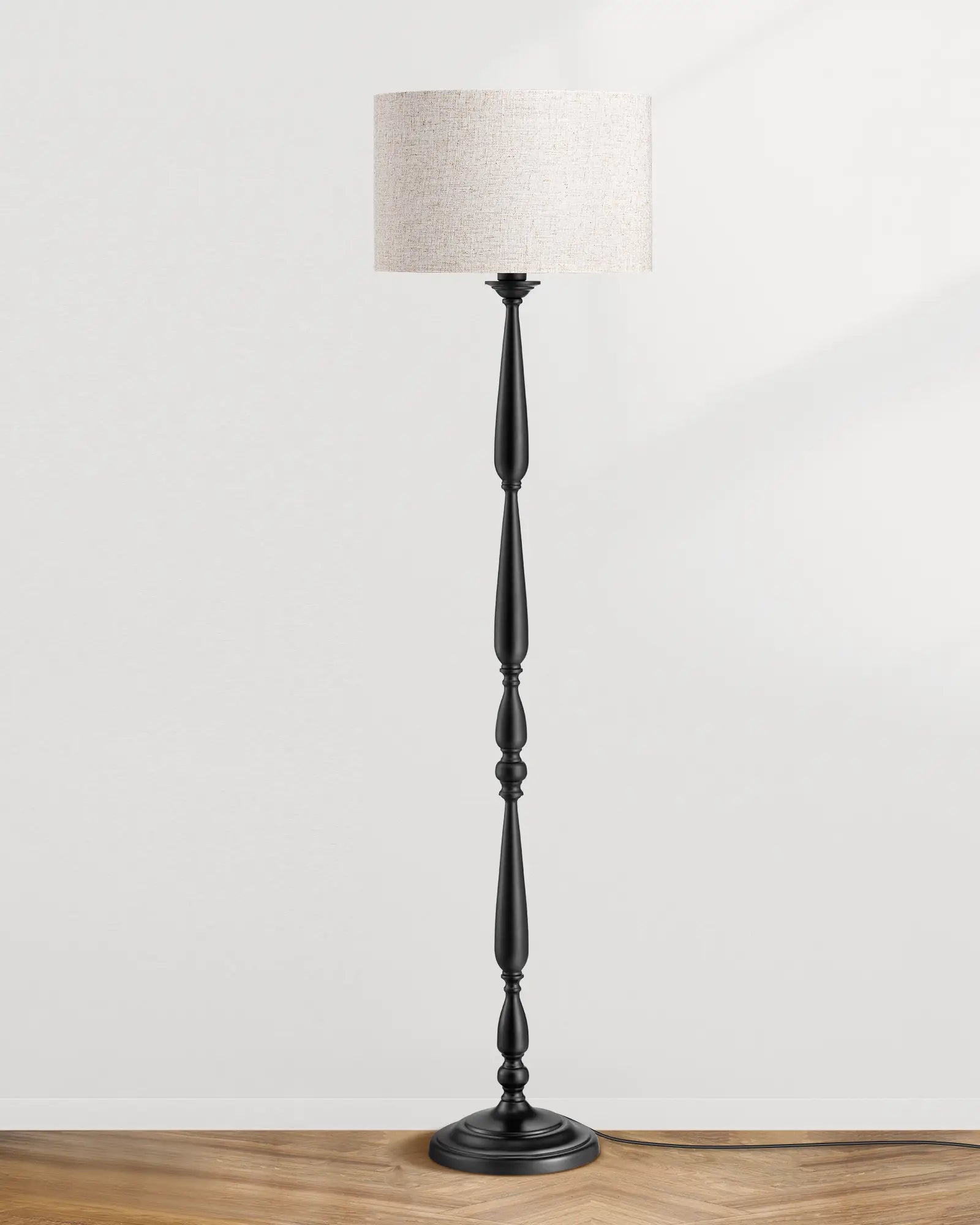 Traditional Floor Lamp with a black base and beige lampshade on a wooden surface.