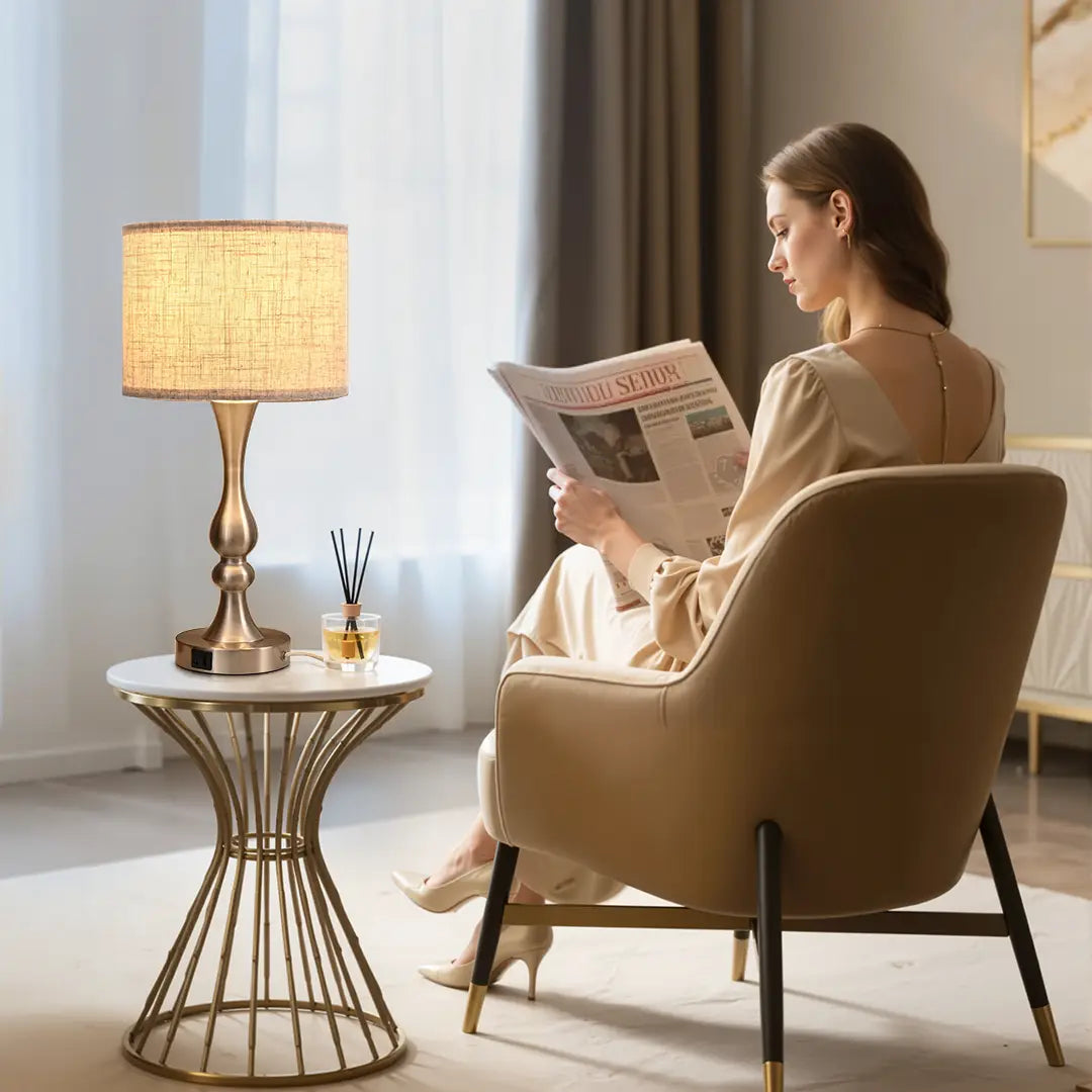 Woman reading a newspaper in a cozy living room with a Traditional Table Lamp and side table.