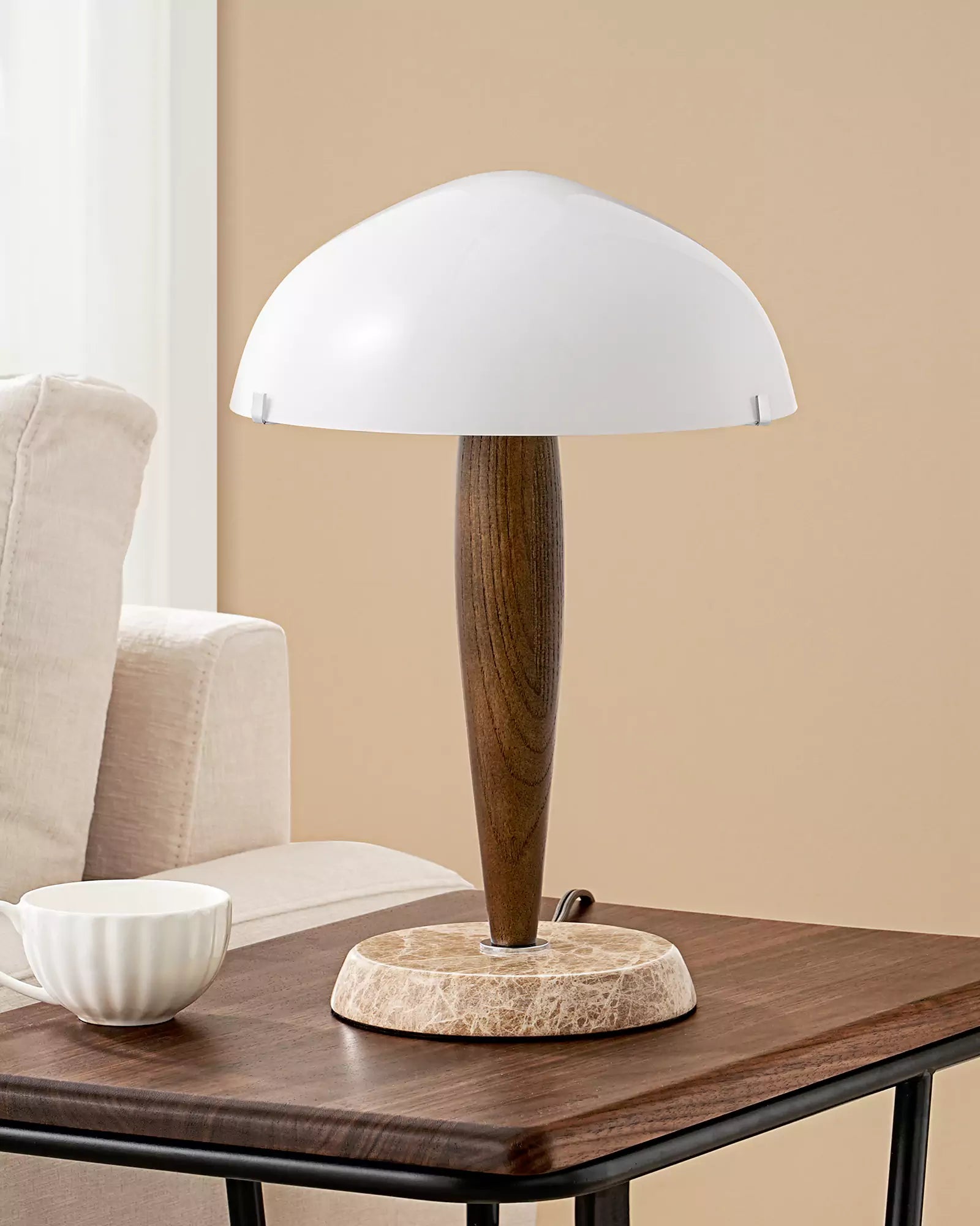 Wood and Marble Table Lamp with wooden base and white shade on a wooden table, beige wall and chair in the background
